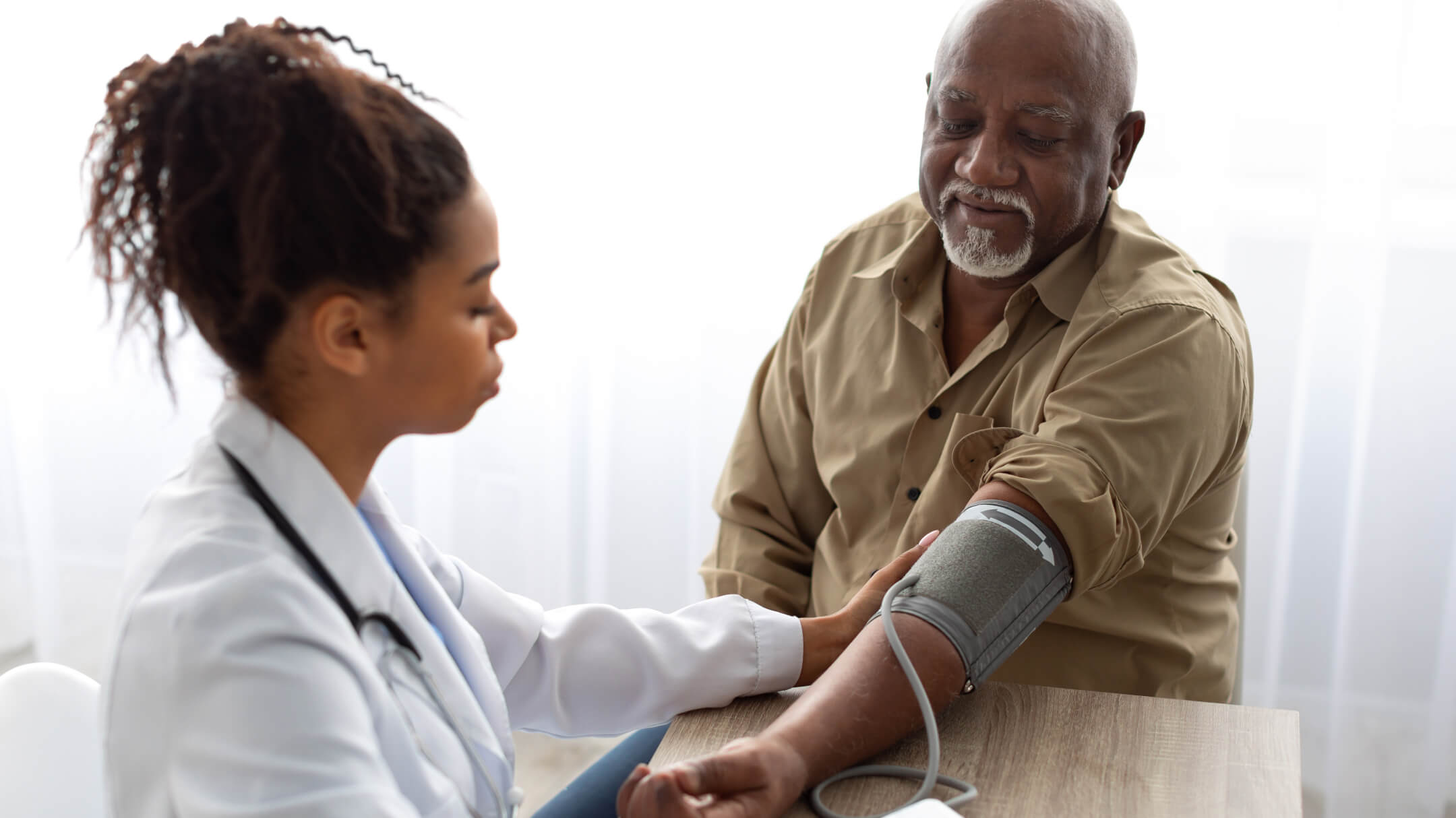 Physician taking blood pressure of medicare patient